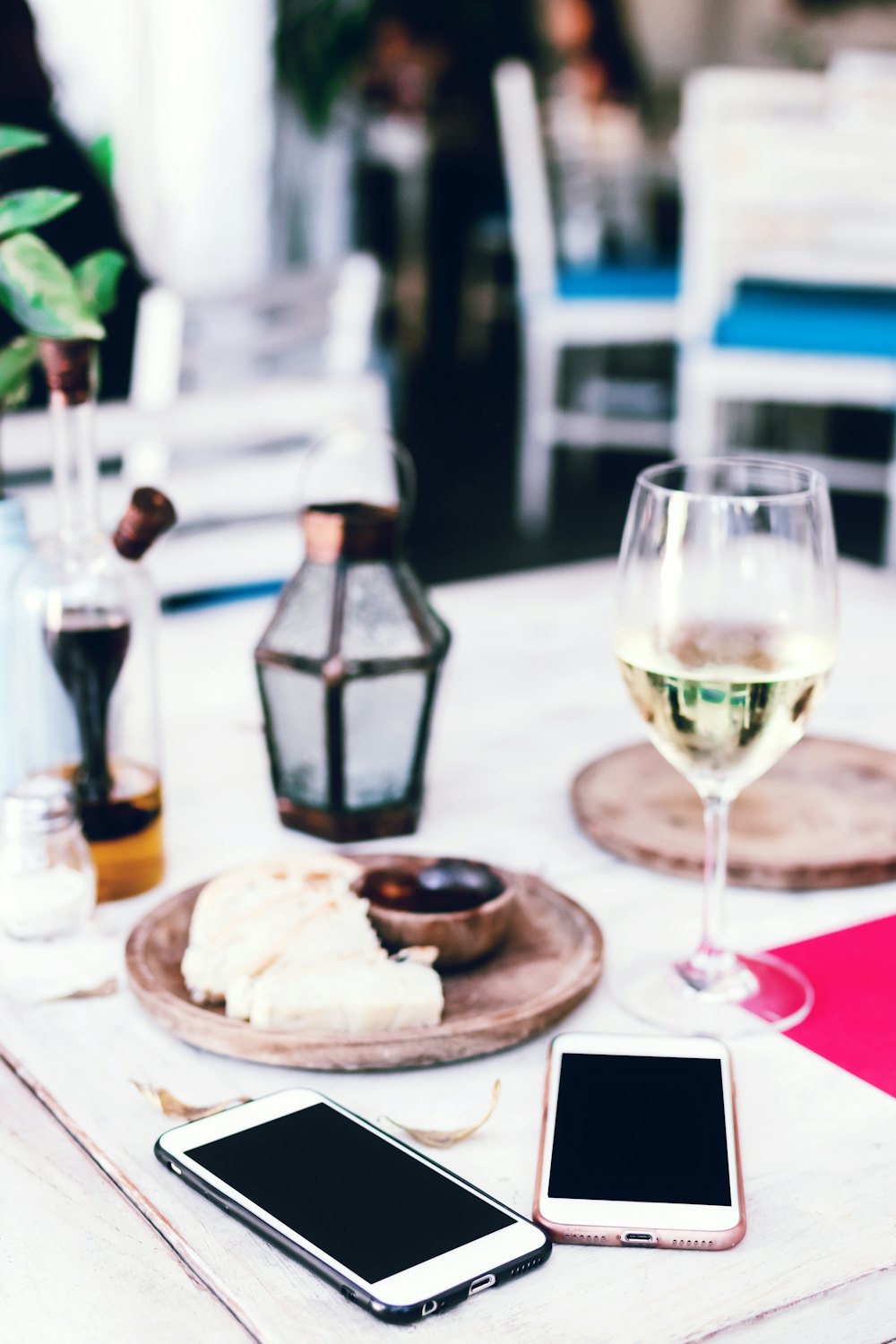 Mesa ao ar livre com taça de vinho e celulares